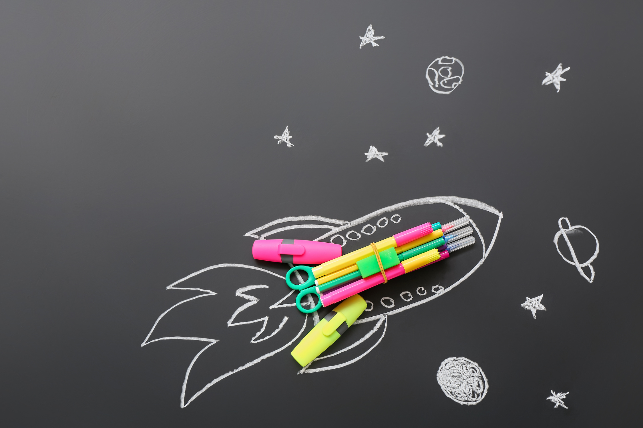 Drawn Rocket with Stationery on Black Background